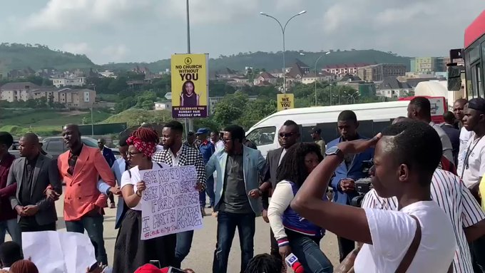 COZA members attempt to stop peaceful protest against their pastor Fatoyinbo  Following the ongoing massive protest by some concerned Nigerians against the Commonwealth of Zion Assembly, COZA, Pastor, Biodun Fatoyinbo, who was accused of serial rape by the Timi Dakolo’s wife, Busola and many other ladies, a counter protest group has emerged, displaying placards in solidarity to the pastor.