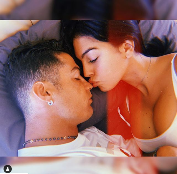 Loved-Up Photo Of Cristiano Ronaldo’s Partner Georgina Rodriquez Planting A Sweet Kiss On Him In Bed      Cristiano Ronaldo‘s partner Georgina Rodriquez took to Instagram to share this loved-up photo of them in bed together. In the photo, the Spanish beauty was pictured planting a sweet kiss on the footballer while he is fast asleep.