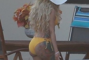 She is holding a phone in her hand and she is probably having another pointless conversation with her friend about some retarded thing that she heard someone say about her.
