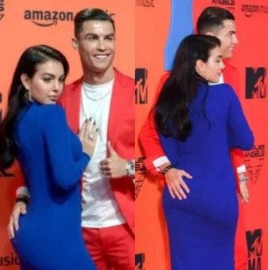 Cristiano Ronaldo and Georgina Rodriguez were a stunning couple at the MTV Europe Music Awards as they turned heads on the red carpet in eye catching outfits. Cristiano looked suave in a bold red suit over a white T-shirt with white trainers while his model girlfriend looked stunning in a dark blue floor-length dress with a dramatic split up to the thigh. She wore her hair loose, finished off her look with huge hoop earrings and white heels, probably to match Cristiano’s fancy footwear. The couple held hands as they posed for the cameras, with Georgina putting her hands tenderly on her man’s chest and Ronaldo softly grabbing her butt as well.