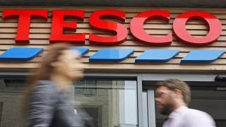 Tesco sees profits halve to £1bn as costs rise