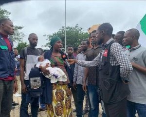 Nursing mother protests with her infant after her husband was killed by bandits